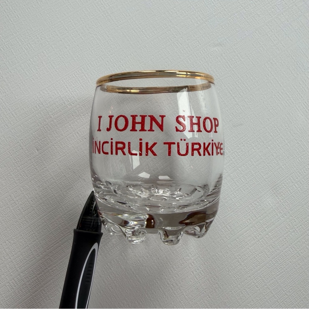 VTG I John Shop in Incirlik, Türkiye shot glass in a gold rim & bold red text